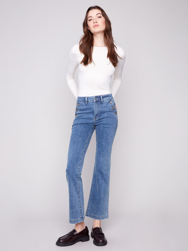 Regular rise medium blue jeans with elegant button accents on the side pockets, designed by Charlie B.
