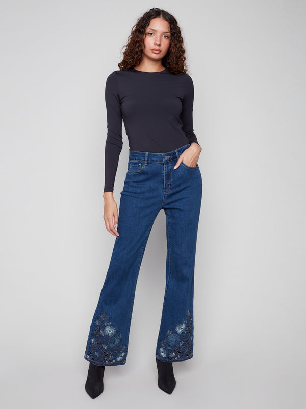 Indigo jeans with a flare fit and floral lace detailing. The stretch denim enhances comfort for everyday wear by Charlie B.