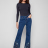 Indigo jeans with a flare fit and floral lace detailing. The stretch denim enhances comfort for everyday wear by Charlie B.