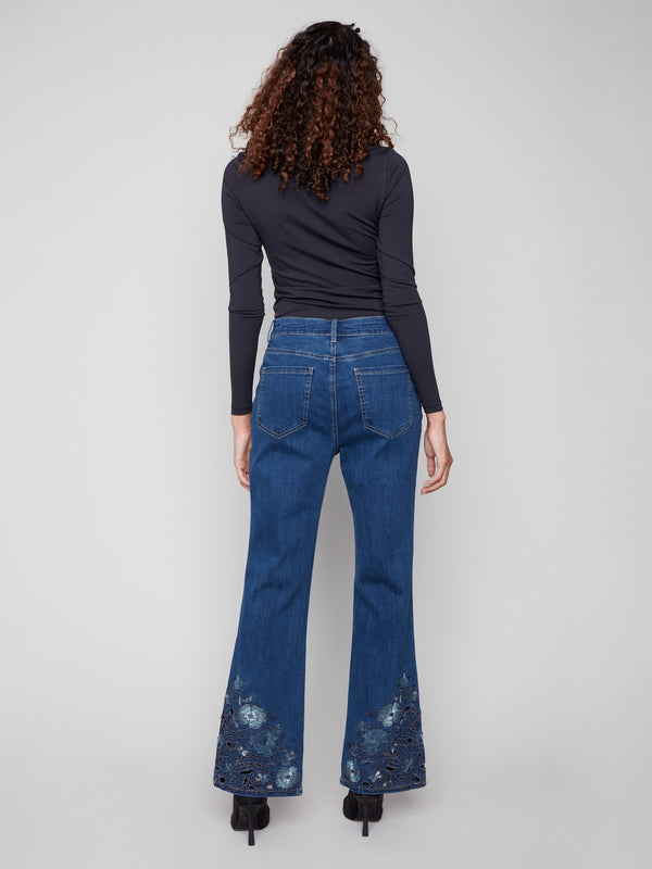 Embrace elegance with these long-length indigo jeans featuring exquisite floral lace embroidery at the hem by Charlie B.