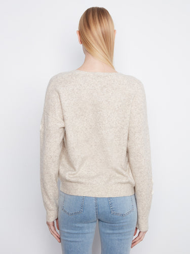 Elegant drop shoulder styling on this heather-almond sweater, complete with floral accents by Charlie B.