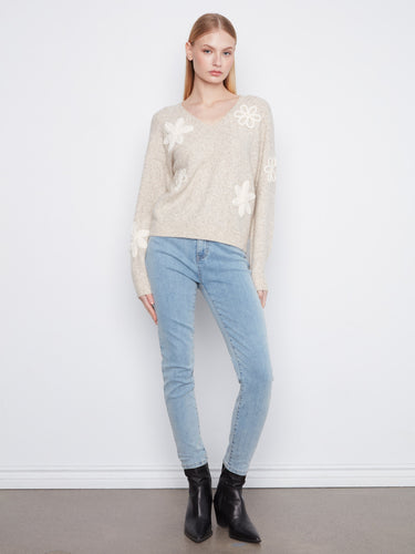 Soft heather-almond tone and unique flower appliqués make this V-neck sweater a standout piece by Charlie B.