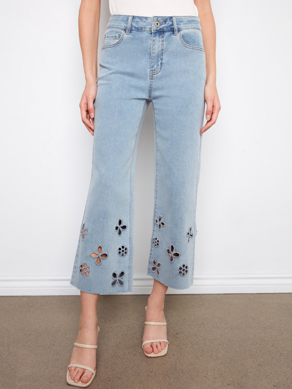 Cropped light blue jeans with a wide leg design and intricate floral cutouts at the hem by Charlie B.