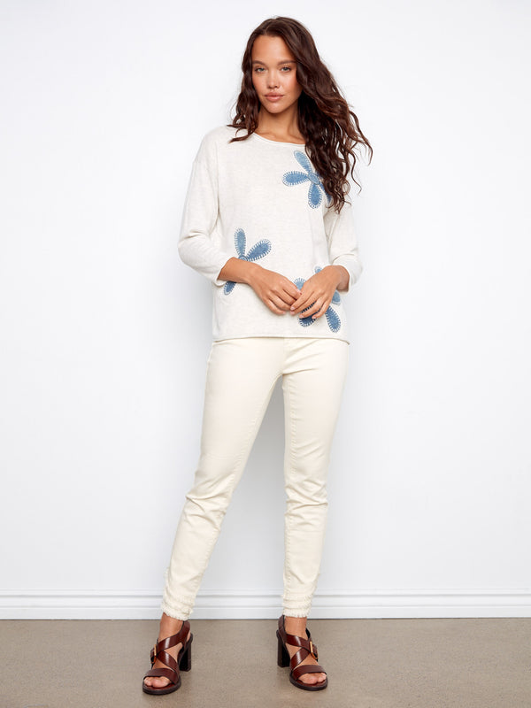 Charming Heather Oat sweater in soft cotton, highlighted by its crew neckline and exquisite floral embroidery by Charlie B.