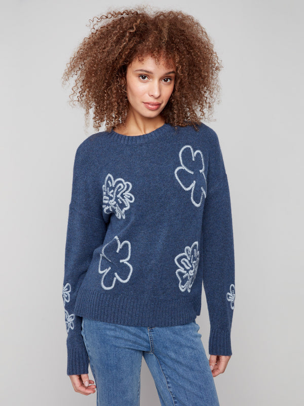 Denim sweater with drop shoulders, adorned with floral embroidery and ribbed details for a cozy feel by Charlie B.