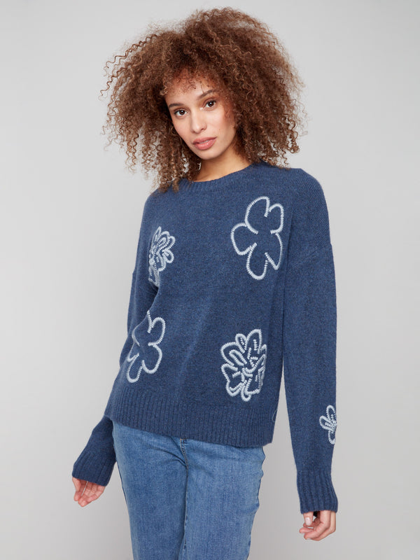 Heather denim sweater showcasing a crew neck and elegant floral embroidery, complete with ribbed accents by Charlie B.