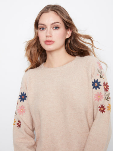 Floral embroidery adorns this charming sweater, bringing elegance to its soft knit blend. By Charlie B.