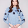 Denim sweater with floral embroidery, showcasing a relaxed fit and ribbed cuffs for comfort by Charlie B.