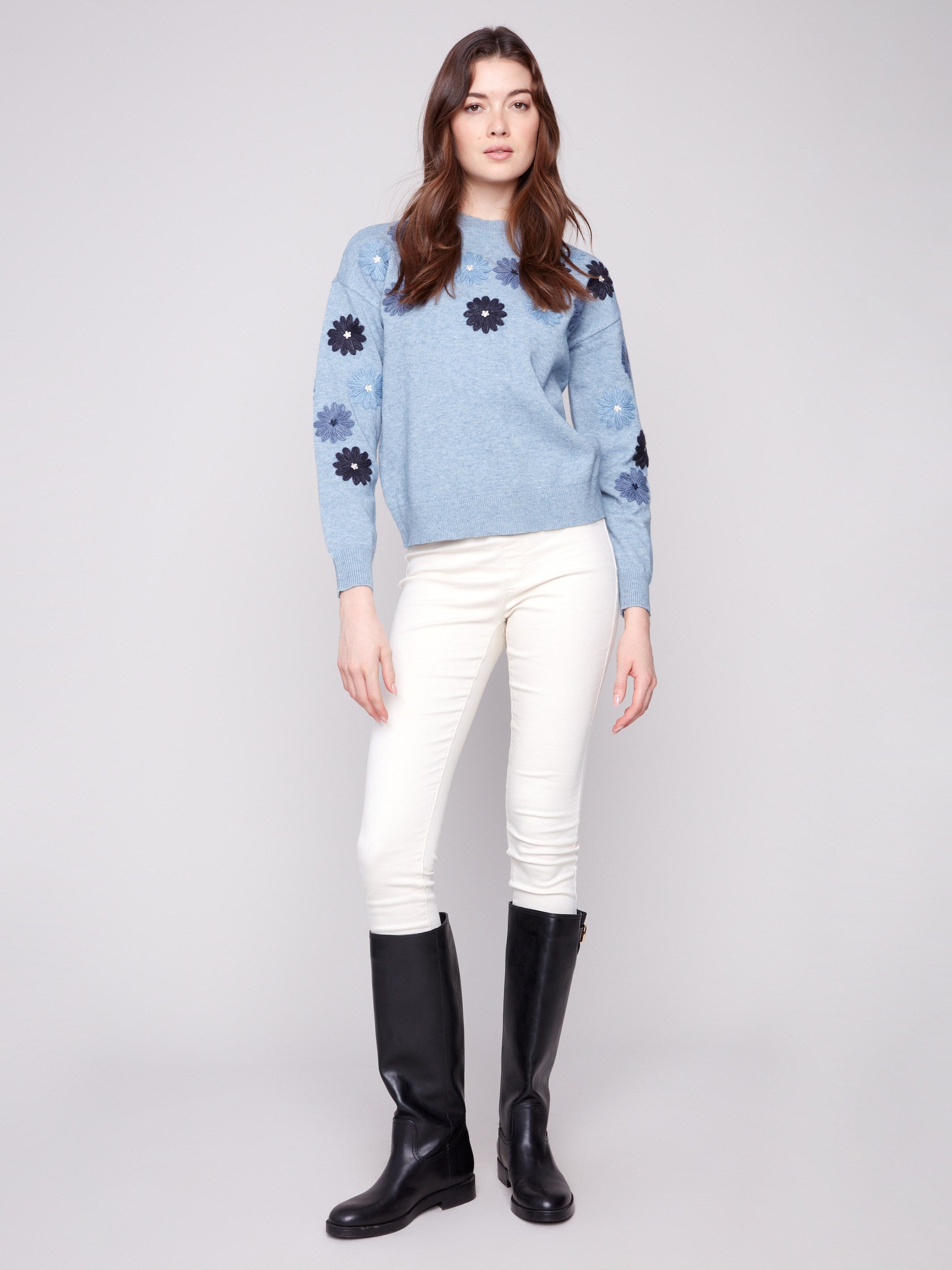 Stylish denim sweater adorned with floral embroidery, featuring a drop shoulders design by Charlie B.