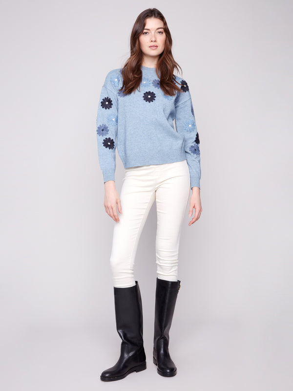 Stylish denim sweater adorned with floral embroidery, featuring a drop shoulders design by Charlie B.