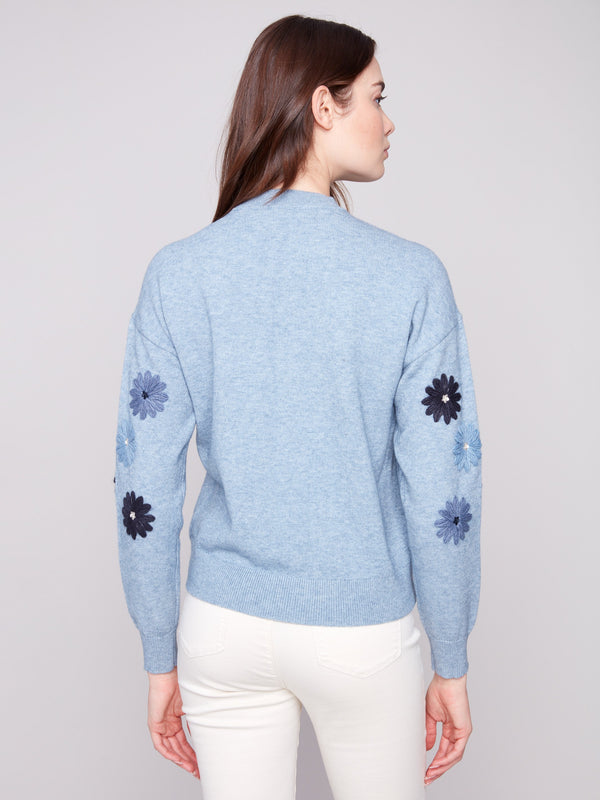 Elegant heather denim sweater with floral details, offering a cozy crew neck style by Charlie B.