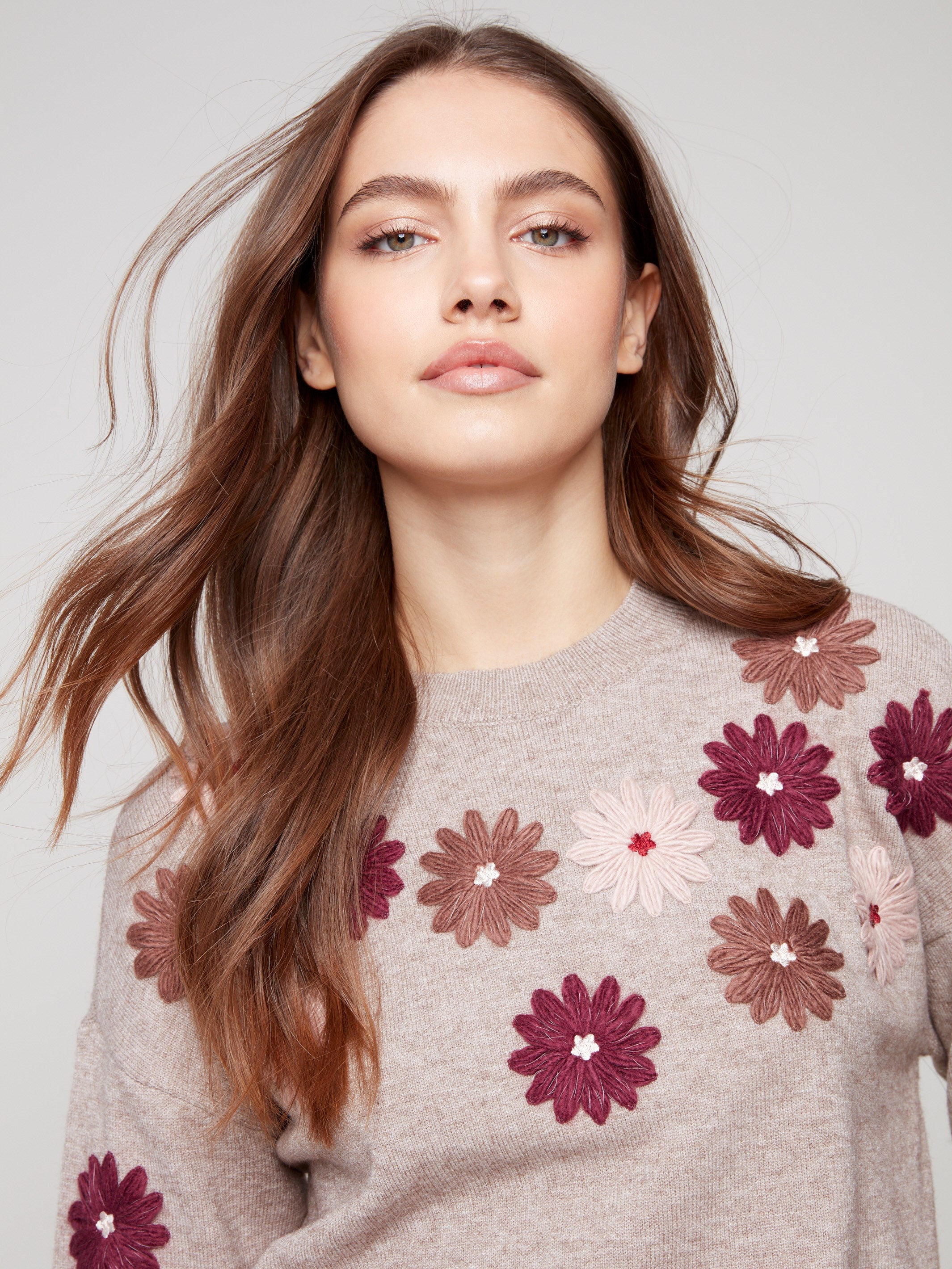 Heather taupe sweater adorned with floral embroidery, showcasing a relaxed fit and ribbed cuffs by Charlie B.