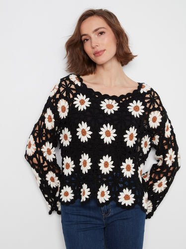 The handcrafted crochet design of this top is beautifully detailed, showcasing a unique floral pattern by Charlie B.