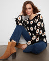 Experience the artful craftsmanship in our daisy-adorned, scallop-hemmed crochet blouse that exudes elegance. By Charlie B.
