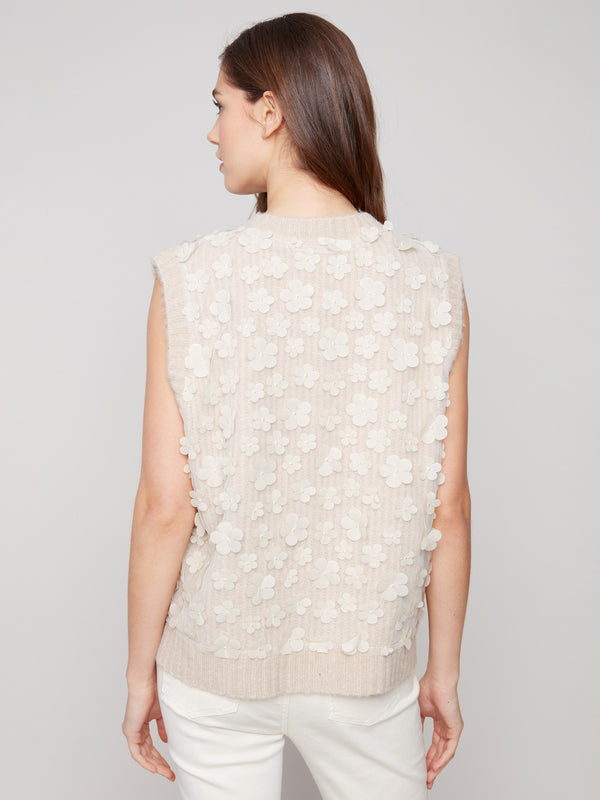 Floral embellishments adorn this sleeveless V-neck sweater vest for a chic look by Charlie B.