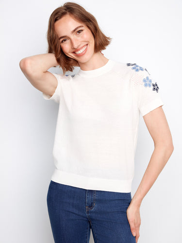 Charming white cotton top with delicate floral appliques adorning the raglan sleeves, perfect for casual outings by Charlie B.