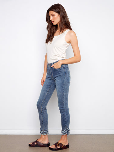 Chic medium blue denim pants featuring a classic five-pocket design and modern frayed hem by Charlie B.