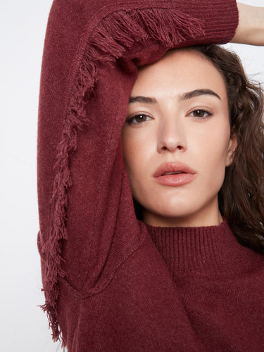 Sweater with intricate fringe detail on the sleeves, adding texture to the Heather-Merlot fabric by Charlie B.