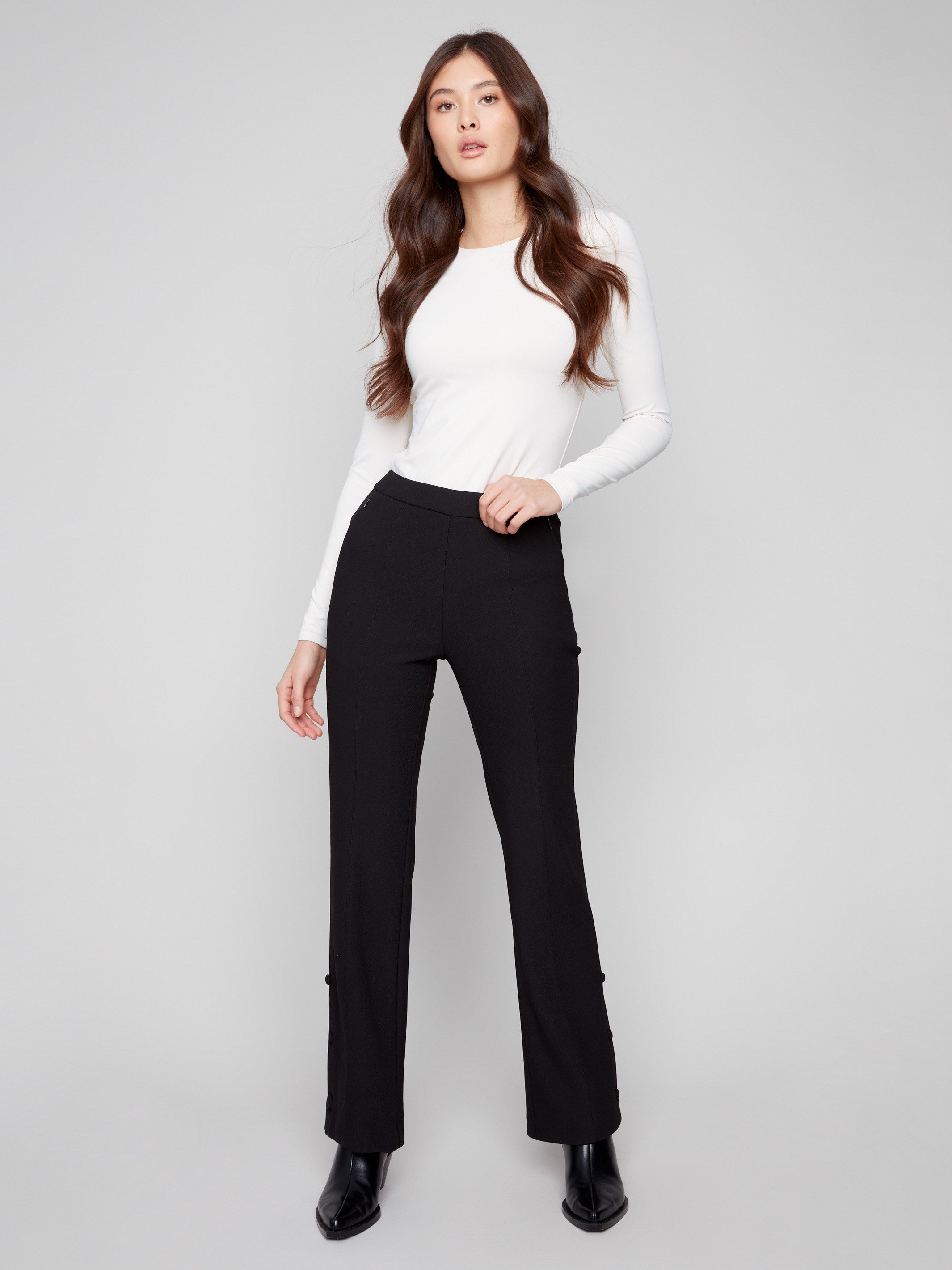 Black pants with a sleek flare fit, paired with a white top, by Charlie B.