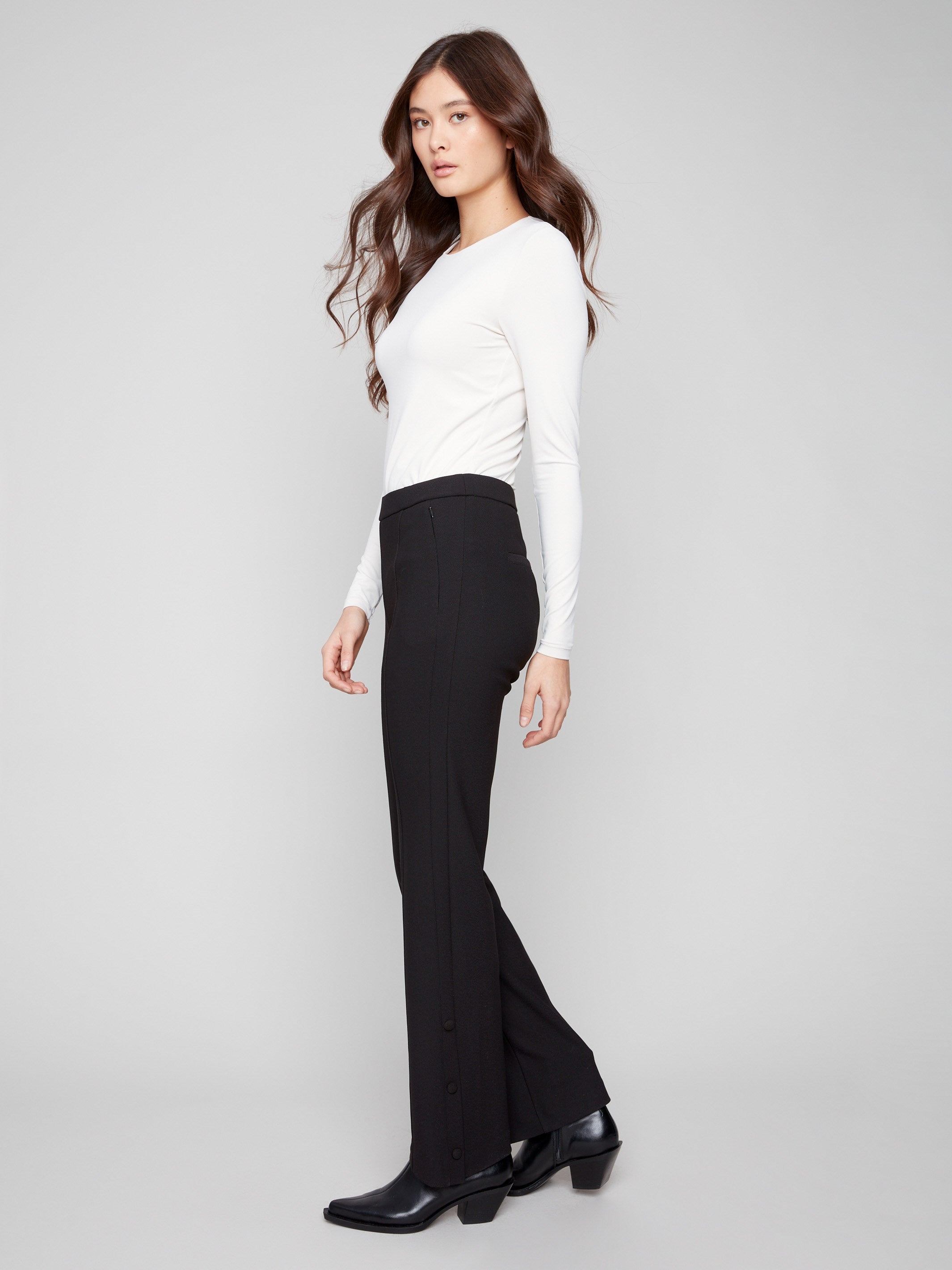 Pants featuring welt pockets and a chic white top ensemble by Charlie B.