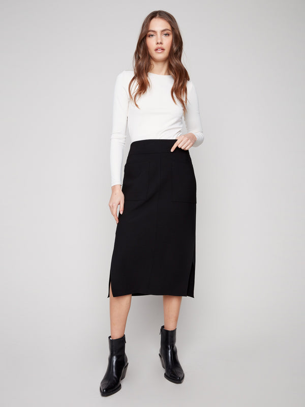 Stylish black skirt showcasing convenient front patch pockets by Charlie B, blending elegance with practicality.