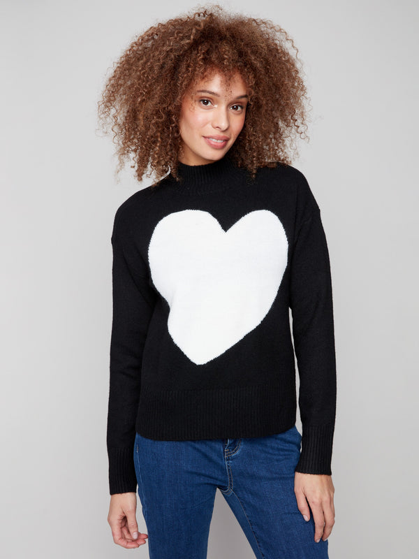 Black sweater adorned with a bold intarsia heart, complemented by ribbed shoulders for added texture by Charlie B.
