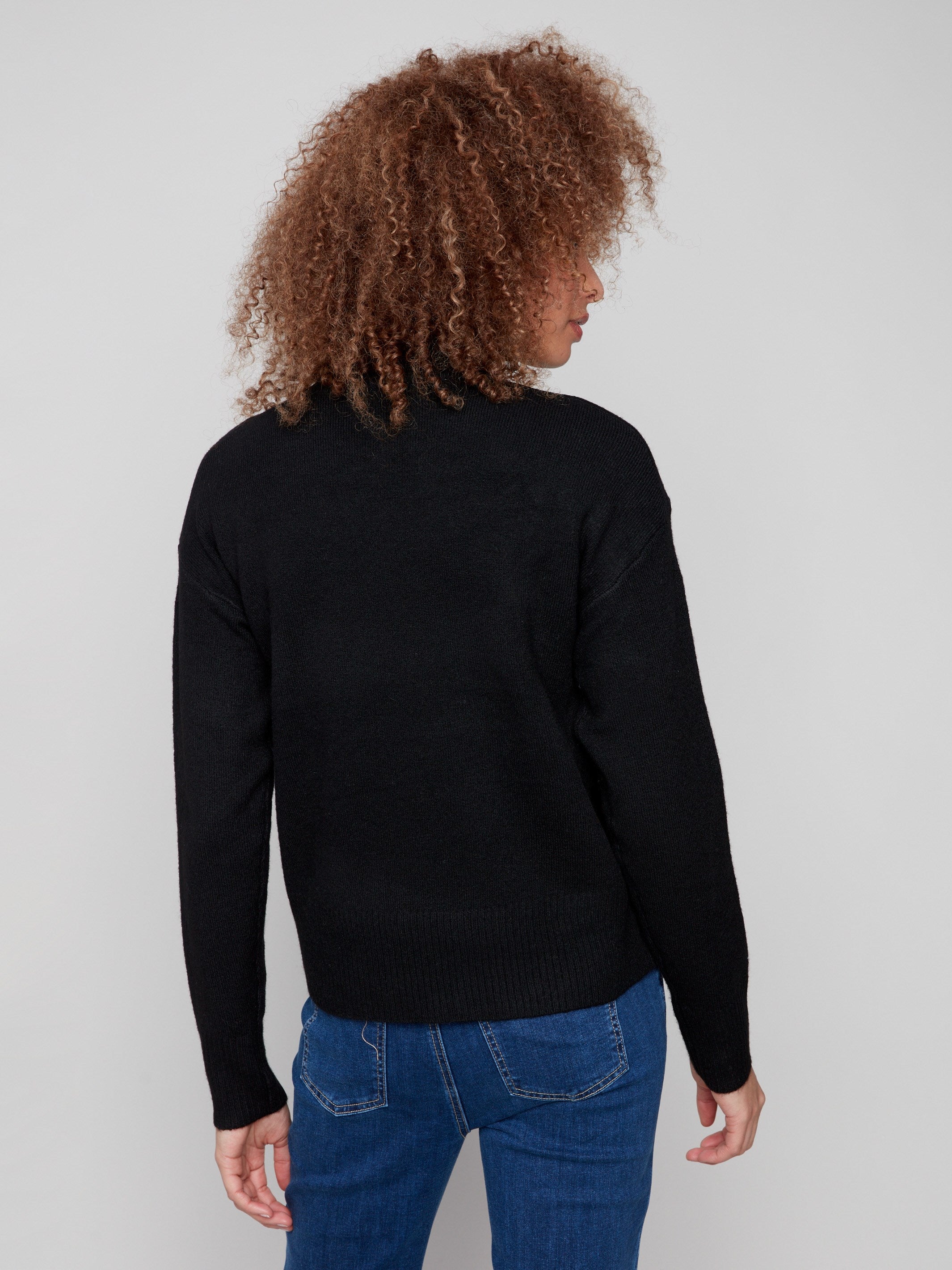 Sophisticated black sweater with drop shoulder design and an eye-catching white heart motif by Charlie B.