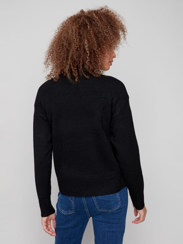Sophisticated black sweater with drop shoulder design and an eye-catching white heart motif by Charlie B.