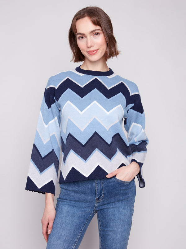 Blue sweater featuring a chevron pattern, paired with casual jeans for a stylish look by Charlie B.