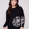 Black sweater with a jacquard floral pattern, showcasing a relaxed fit design and long sleeves for comfort by Charlie B.