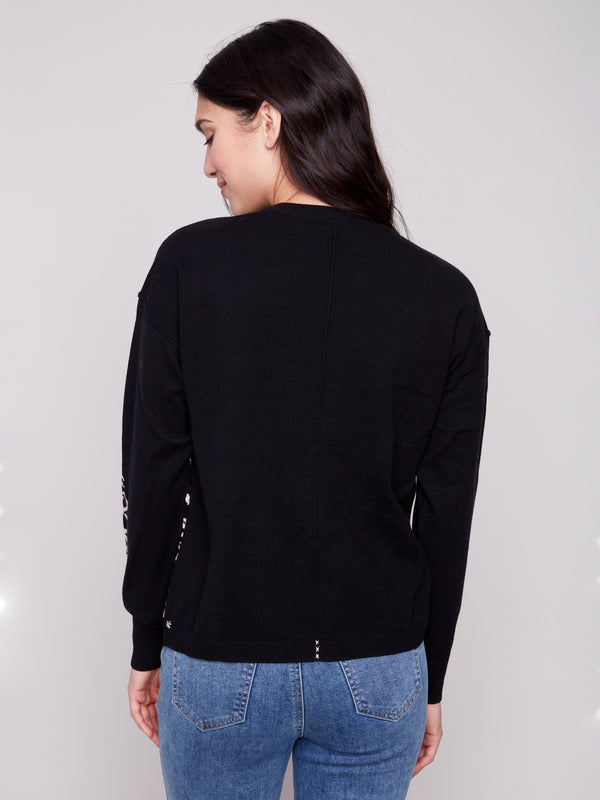Featuring a relaxed fit, this black sweater highlights an intricate jacquard pattern on the sleeve and front by Charlie B.