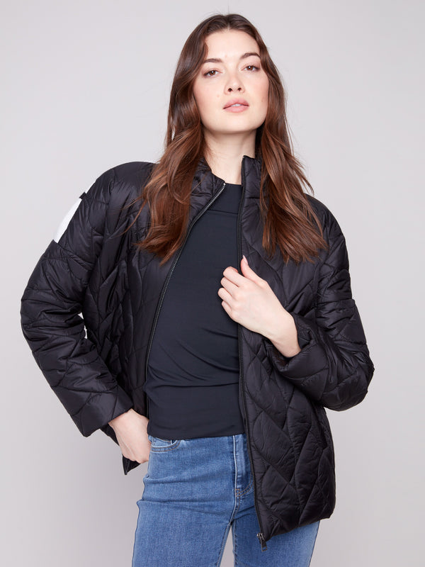 Chic black jacket designed with comfortable quilted fabric, ensuring warmth and style in cooler weather by Charlie B.
