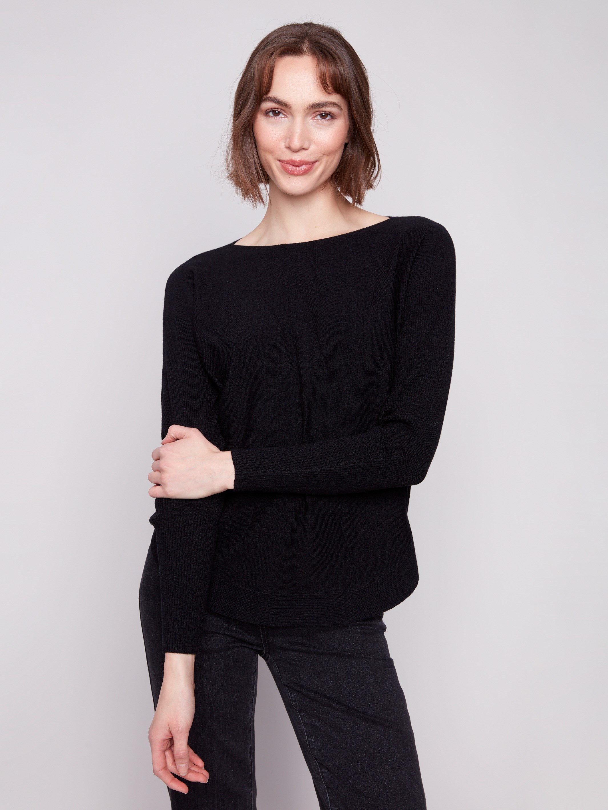 Sophisticated black sweater designed with convenient front pockets for added style by Charlie B.