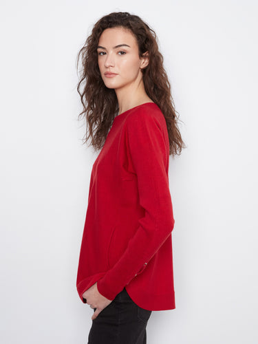Red sweater with a rounded hem adds a modern flair to your casual wardrobe essentials. By Charlie B.