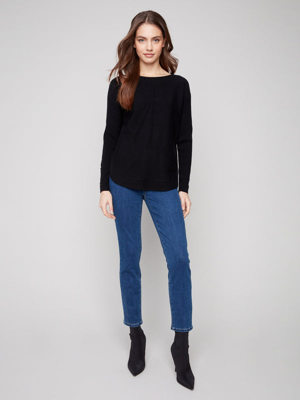 Chic black knit sweater showcasing a rounded hem and comfortable long ribbed sleeves for added warmth by Charlie B.