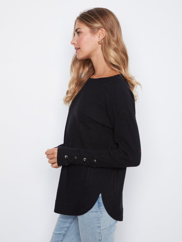 Chic black sweater with side pockets and a flattering boat neck design, complemented by unique lace-up cuffs by Charlie B.