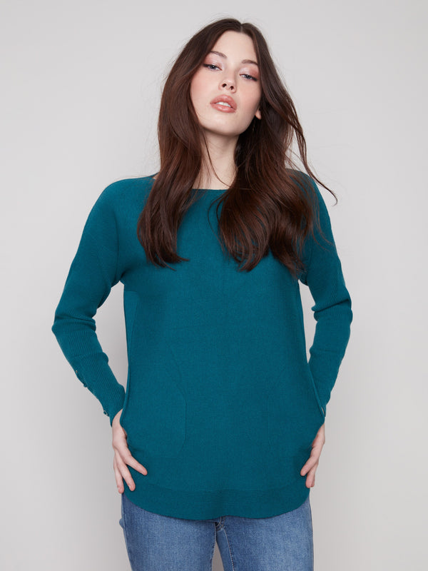Stylish evergreen sweater showcasing cuff lace-up detail and practical side pockets, ideal for everyday wear by Charlie B.