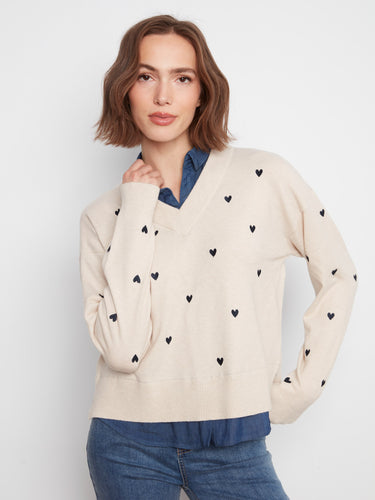 Sweater with a V-neckline and embroidered heart accents, paired with a layered shirt collar for a chic look by Charlie B.