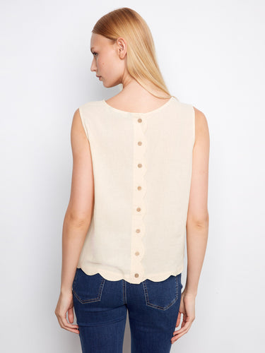 This white sleeveless top has a loose fit with charming scalloped edges, ideal for any occasion by Charlie B.