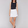 White linen blend skort with short length, styled with a black sleeveless top, by Charlie B.