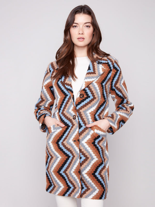 Welt pockets add functionality to this long crochet coat in sepia, highlighted by its unique geometric pattern by Charlie B.