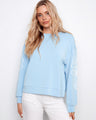 Light blue scuba top with a crew neckline, featuring intricate soutache detailing on the sleeves. Relaxed fit by Charlie B.