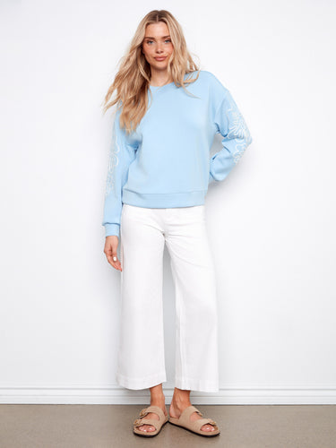 Scuba top in light blue with relaxed fit and delicate soutache accents on sleeves. Drop shoulders complete the look by Charlie B.