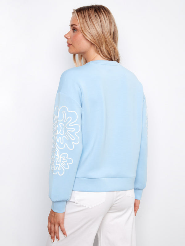Elegant light blue top showcasing a relaxed fit and crew neckline, enhanced by unique soutache details on sleeves by Charlie B.