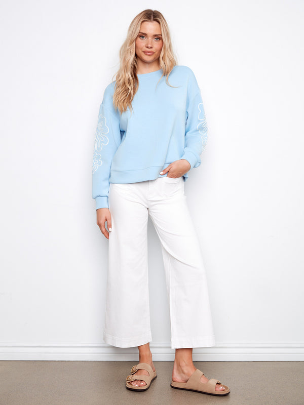 Chic light blue long sleeve top with drop shoulders and charming soutache embellishments. Crew neck style by Charlie B.