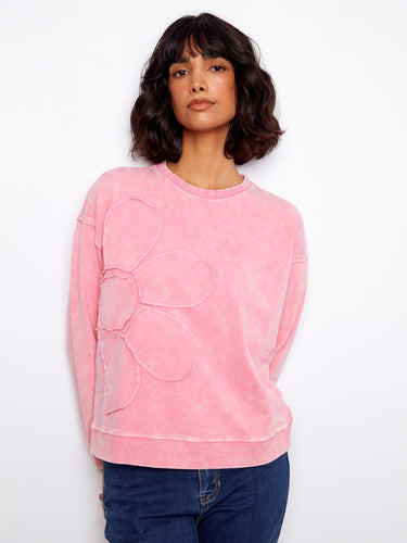 Relaxed pink pullover adorned with flower details, combining elegance and whimsy in one stylish piece by Charlie B.