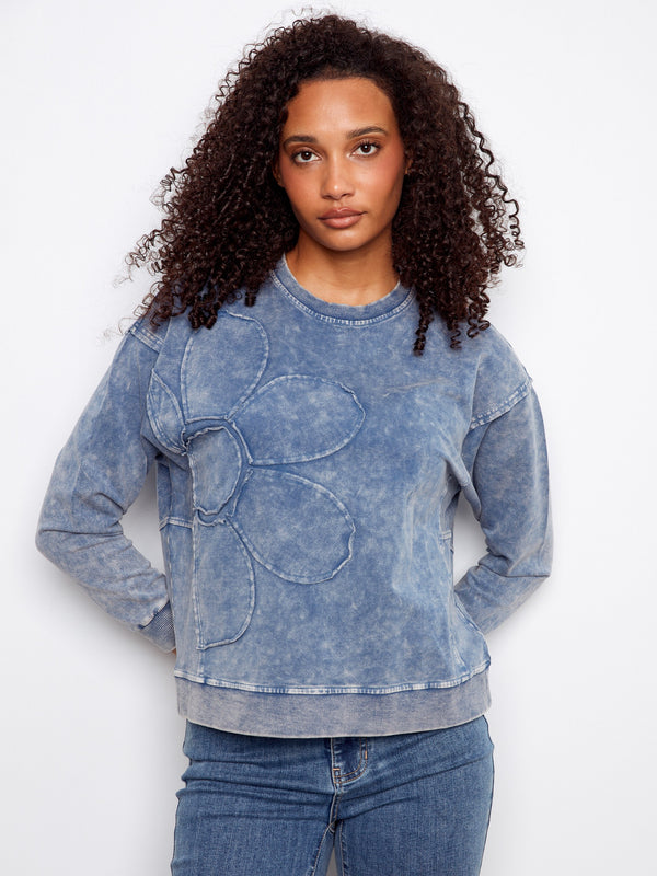 Blue sweatshirt with a crew neckline and a subtle flower applique design, offering a stylish touch to casual wear by Charlie B.