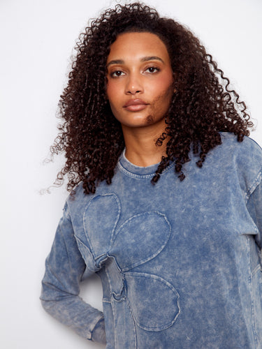 Elegant ribbed neck, hem, and cuffs enhance the classic look of this blue sweatshirt with flower detailing by Charlie B.