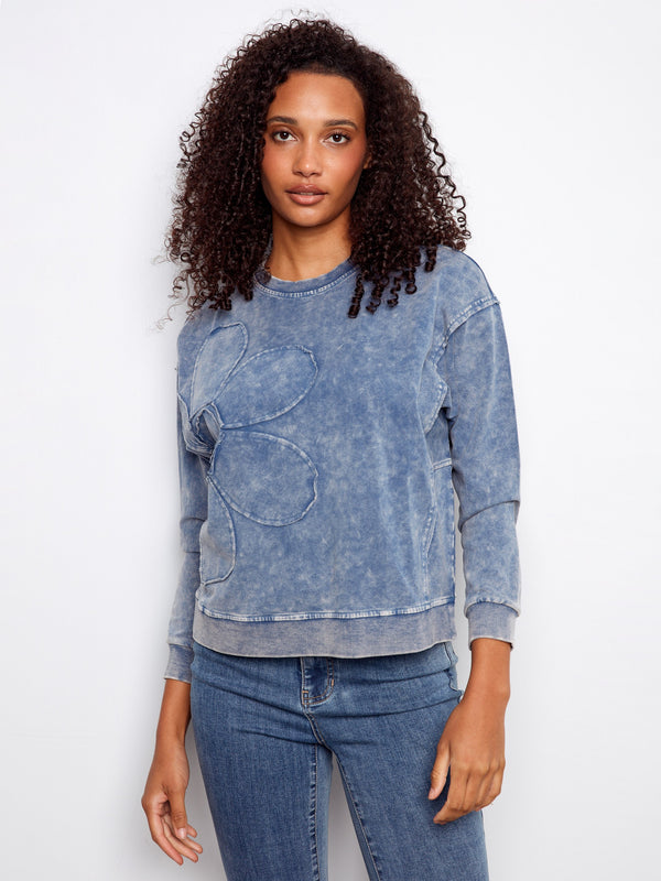 The flower applique adds charm to this blue sweatshirt, making it a standout piece for any wardrobe by Charlie B.