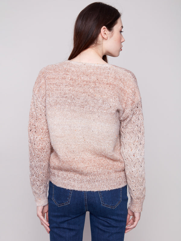 Elegant sweater in latte hue showcasing intricate open knit sleeves, perfect for layering by Charlie B.